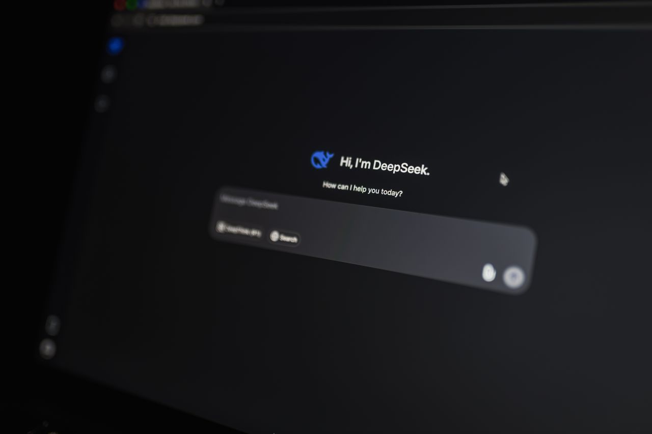 Close-up of a laptop screen showing an AI chat assistant interface in a dim room